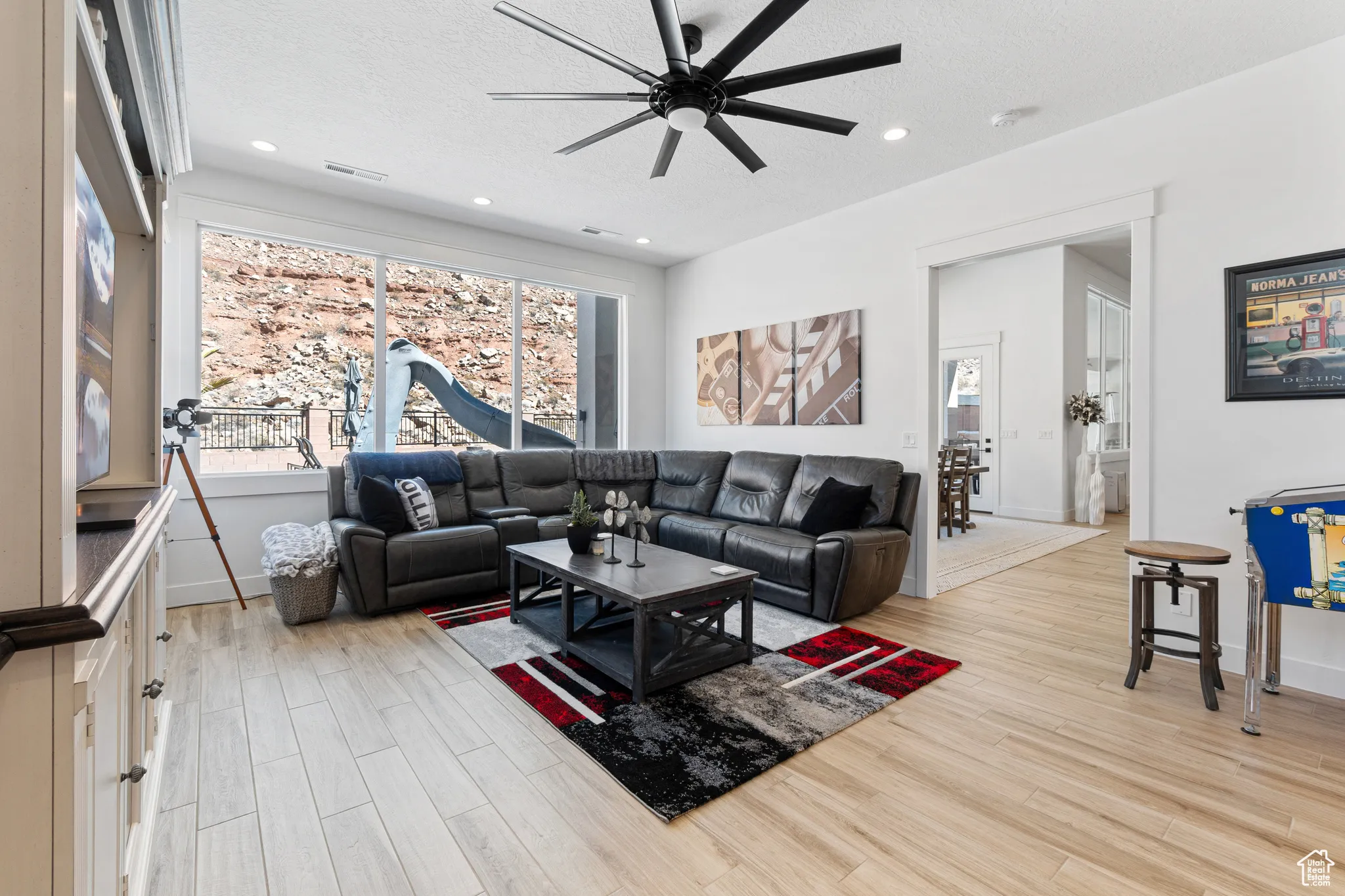 Living room featuring a ceiling fan, light wood finished floors, a textured ceiling, and recessed lighting