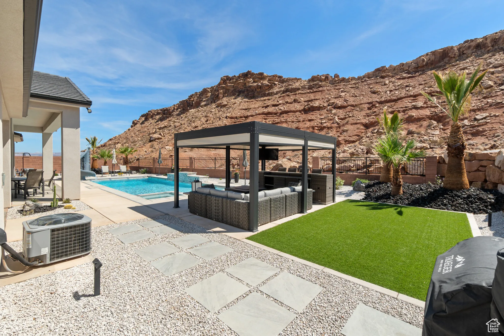 View of pool featuring a mountain view, outdoor lounge area, a gazebo, a fenced backyard, and a patio