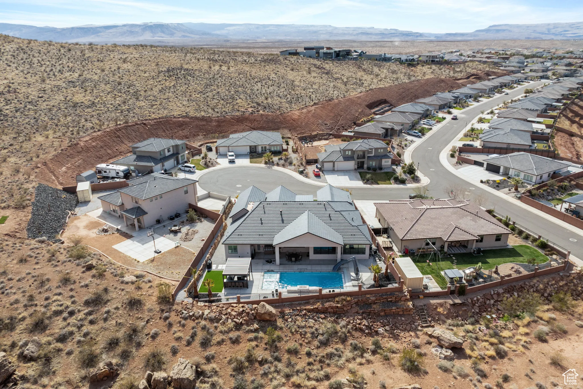 Aerial view of residential area featuring a pool and mountains