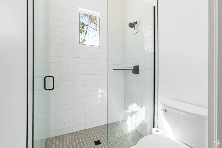 Full bath featuring toilet and a shower stall
