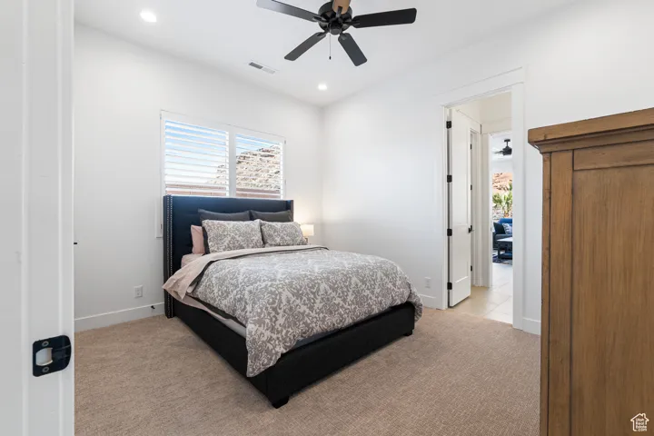 Bedroom featuring light carpet, multiple windows, recessed lighting, and ceiling fan