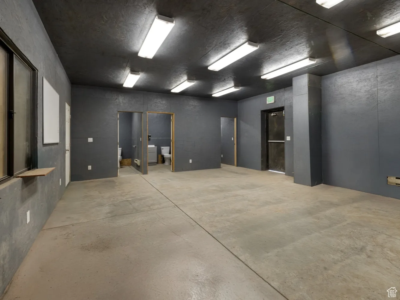 Empty room with a baseboard heating unit, concrete floors, and washer / dryer