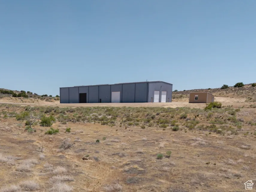 View of yard featuring a pole building, an outbuilding, a view of rural / pastoral area, and a detached garage