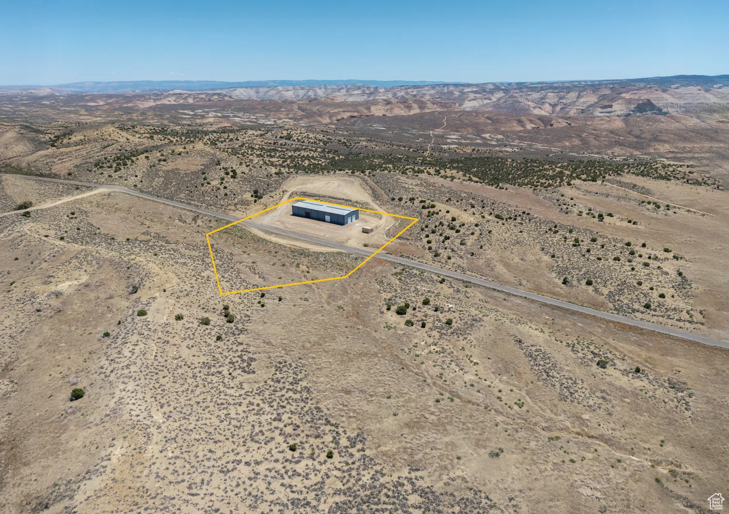 Aerial view of sparsely populated area featuring property parcel outlined and a mountainous background