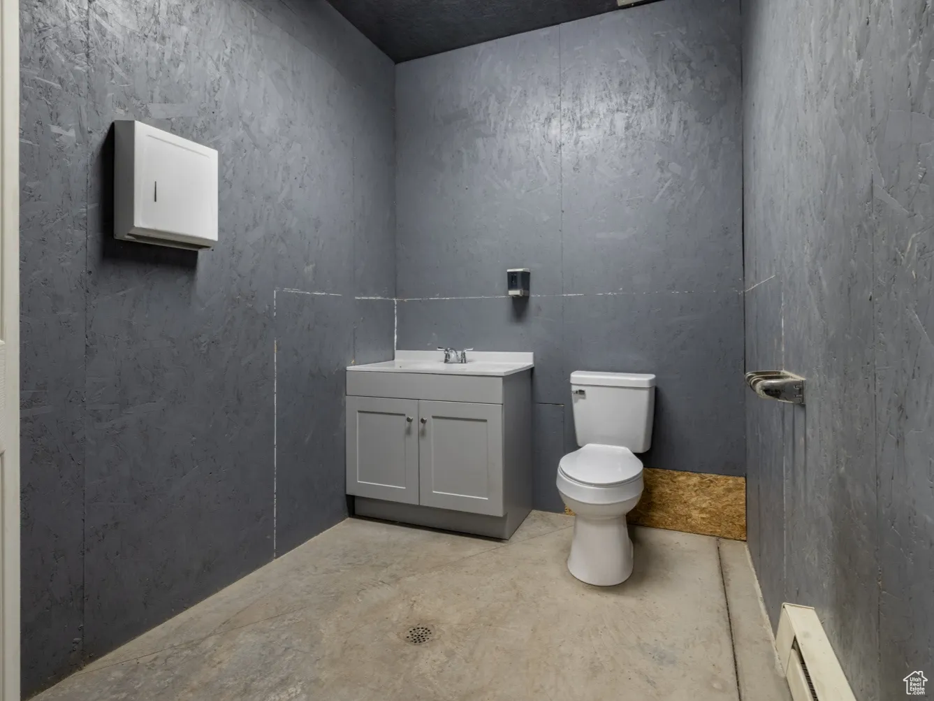 Half bath featuring baseboard heating and vanity