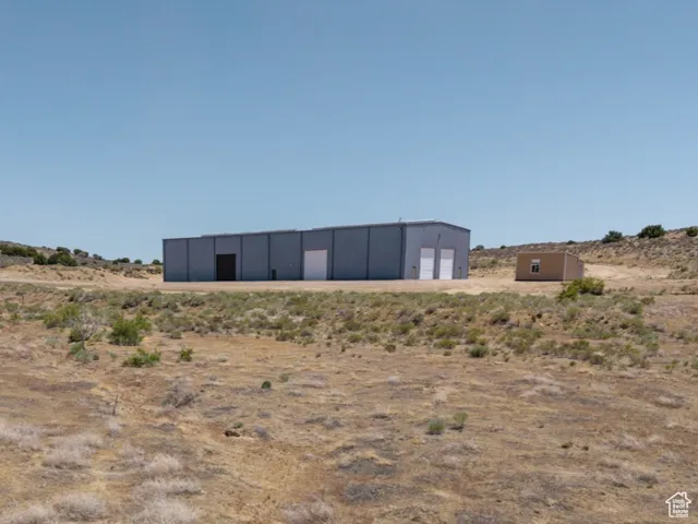 View of yard featuring a pole building, an outbuilding, a view of rural / pastoral area, and a detached garage
