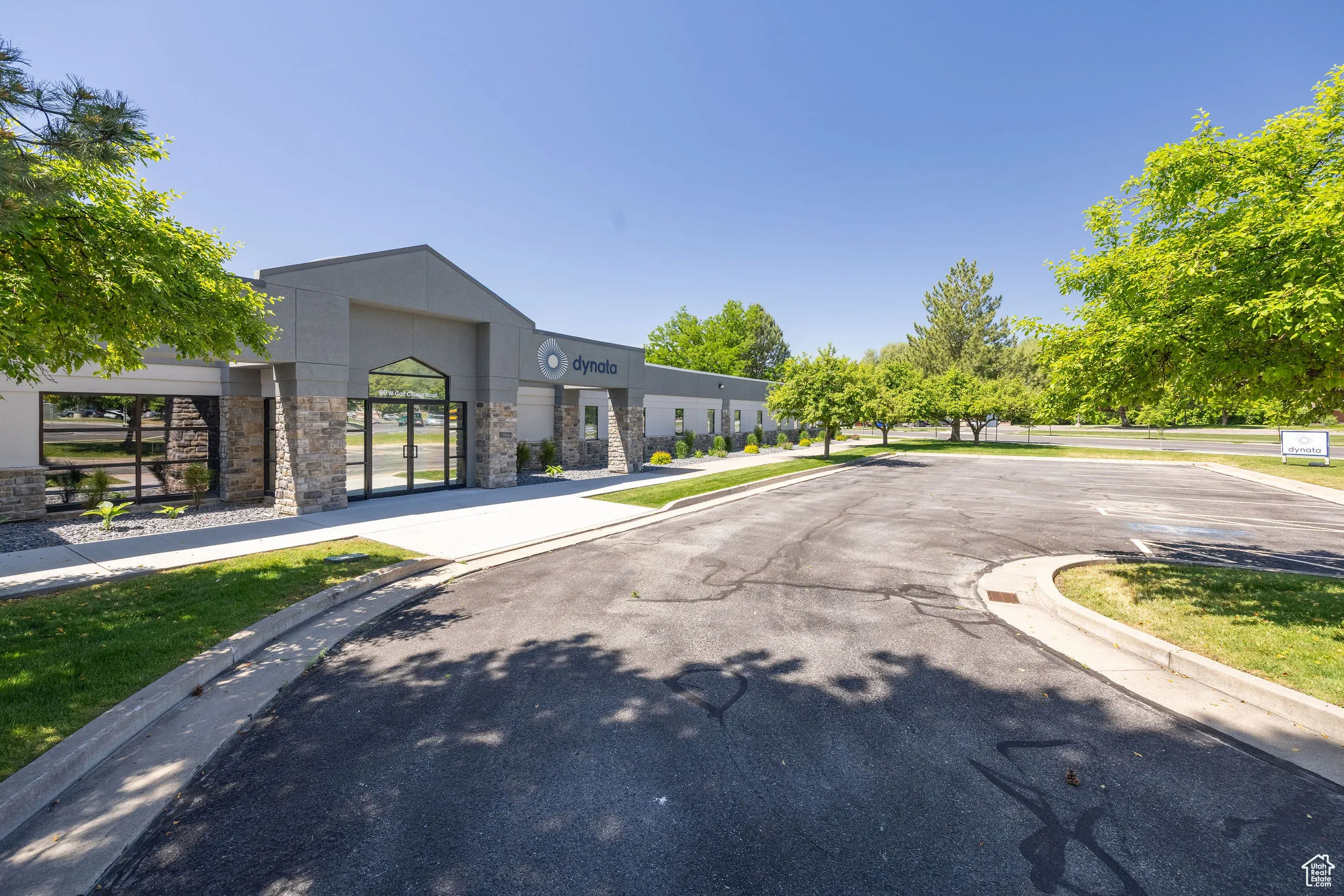 View of asphalt road featuring curbs and sidewalks