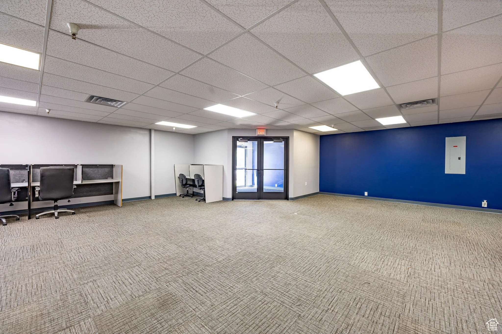 Unfurnished office with carpet flooring, electric panel, and a drop ceiling