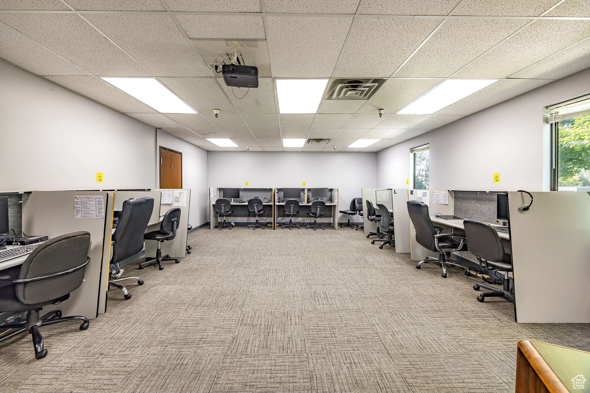Office area with carpet flooring and a drop ceiling