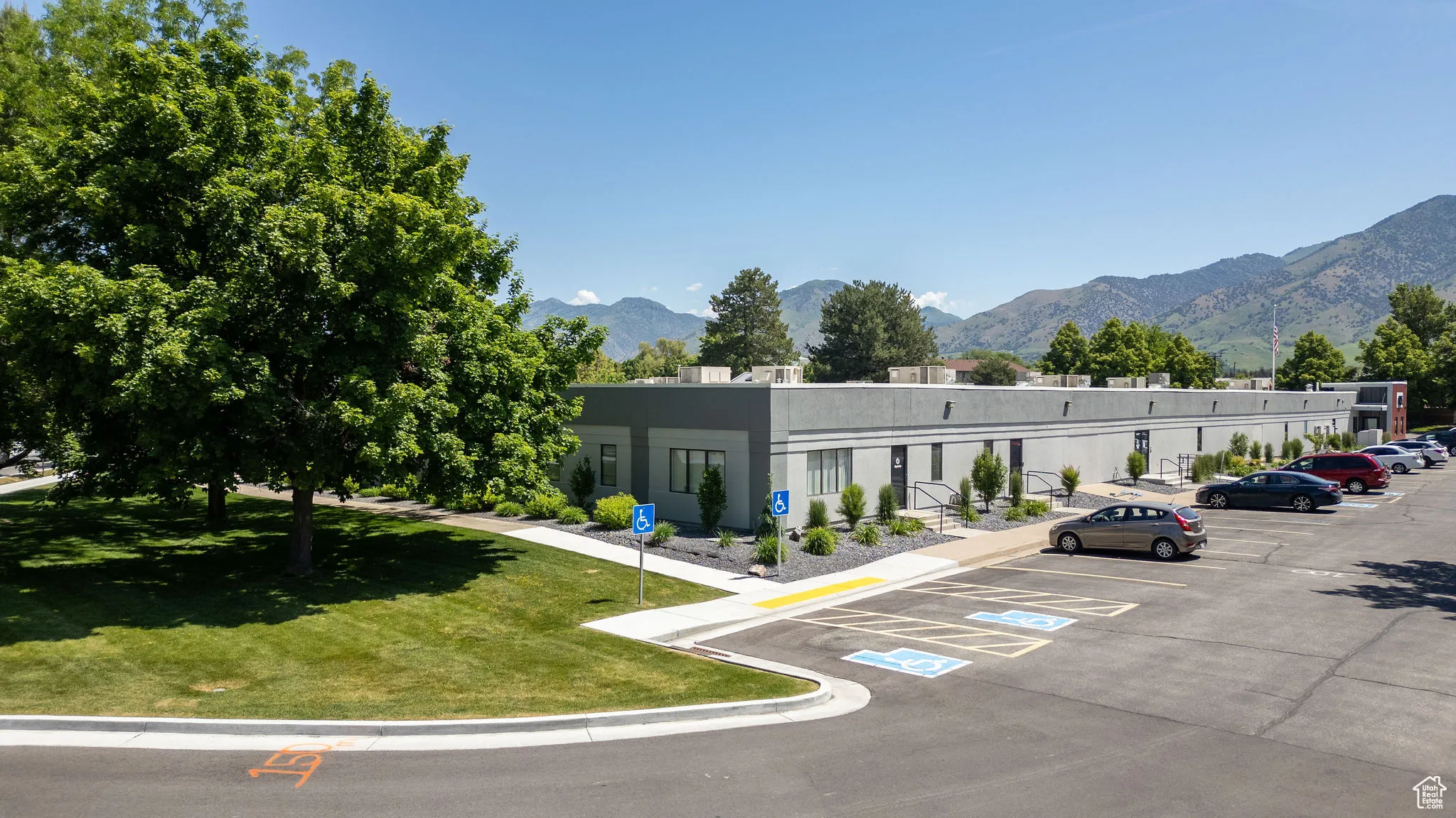 View of building exterior featuring a mountain view and uncovered parking