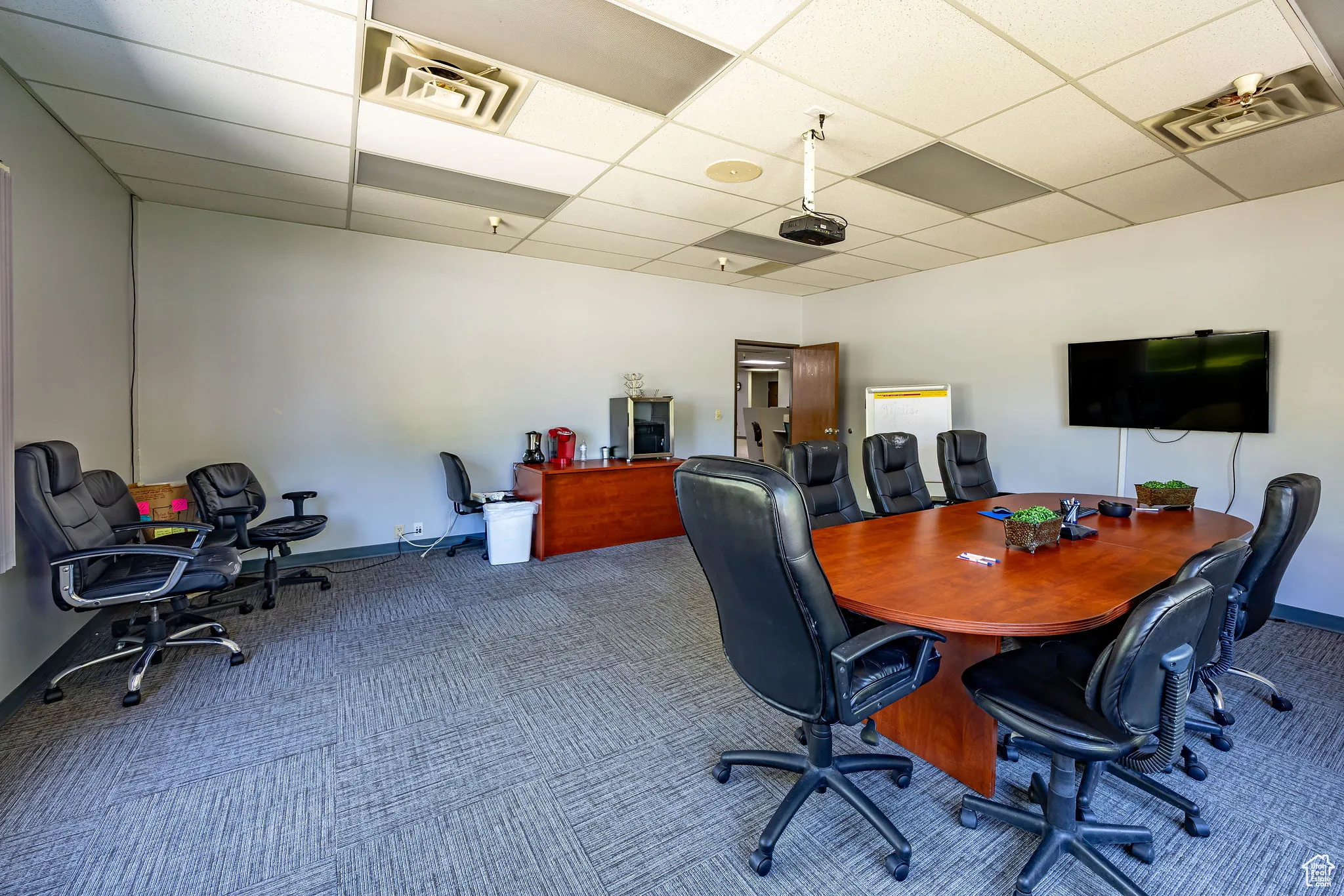 Home office with a paneled ceiling and carpet