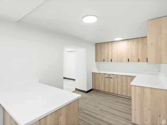 Kitchen with light brown cabinets, a peninsula, and light countertops