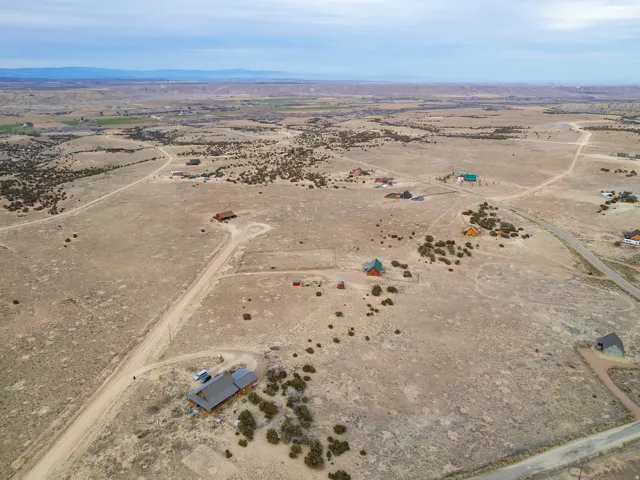 Aerial view of property and surrounding area featuring rural landscape and a mountainous background