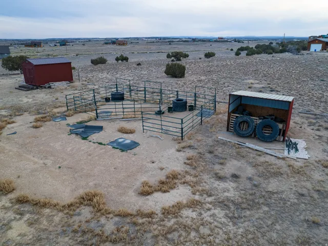 View of yard featuring a view of countryside, a storage unit, and a desert view