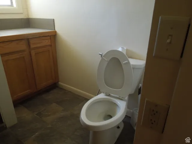 Bathroom with baseboards and stone finish floors