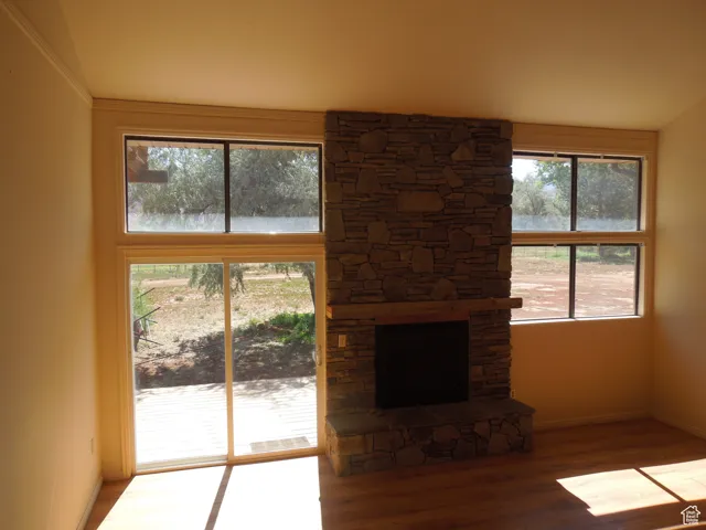 Unfurnished living room featuring wood finished floors and a fireplace