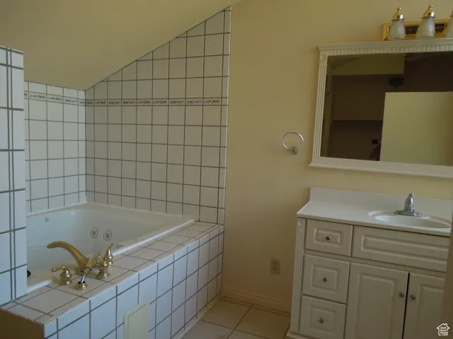 Bathroom with a whirlpool tub, vanity, and tile patterned flooring