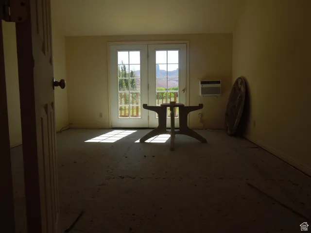 Spare room featuring carpet floors and a wall mounted air conditioner. Buyer to choose carpet at Seller's expense.