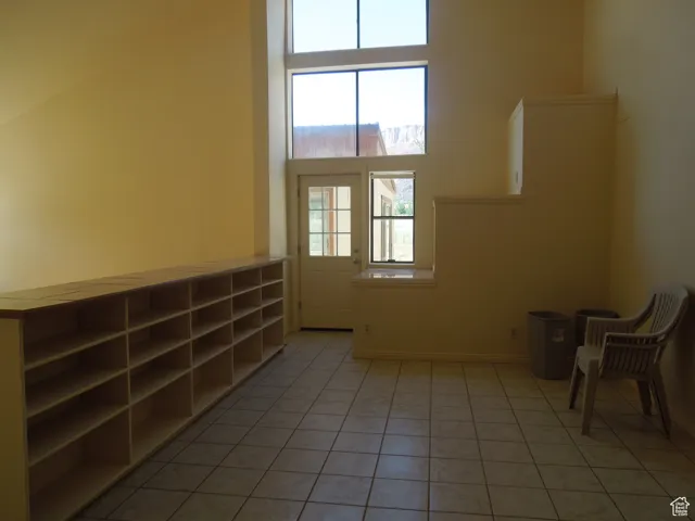 Empty room with light tile patterned flooring and baseboards