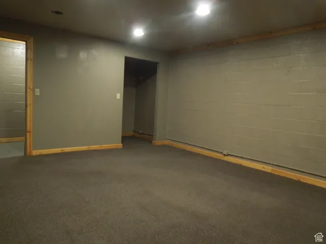 Finished basement featuring recessed lighting, concrete block wall, and carpet