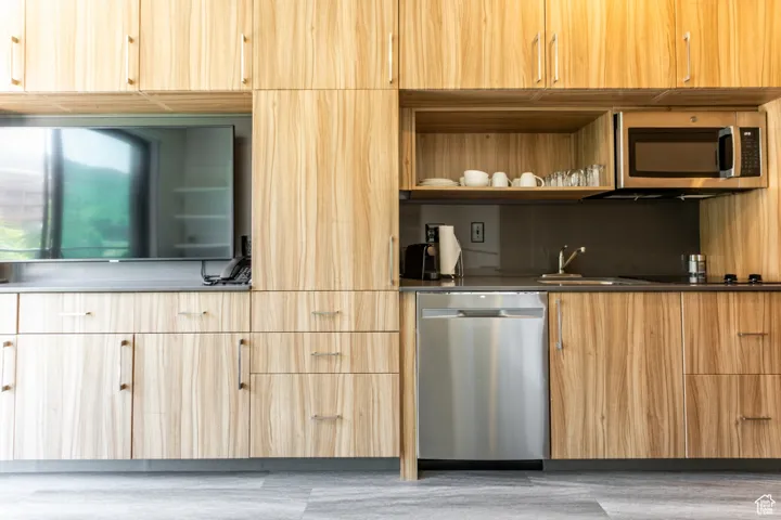 Kitchen with stainless steel appliances, modern cabinets, and light brown cabinets
