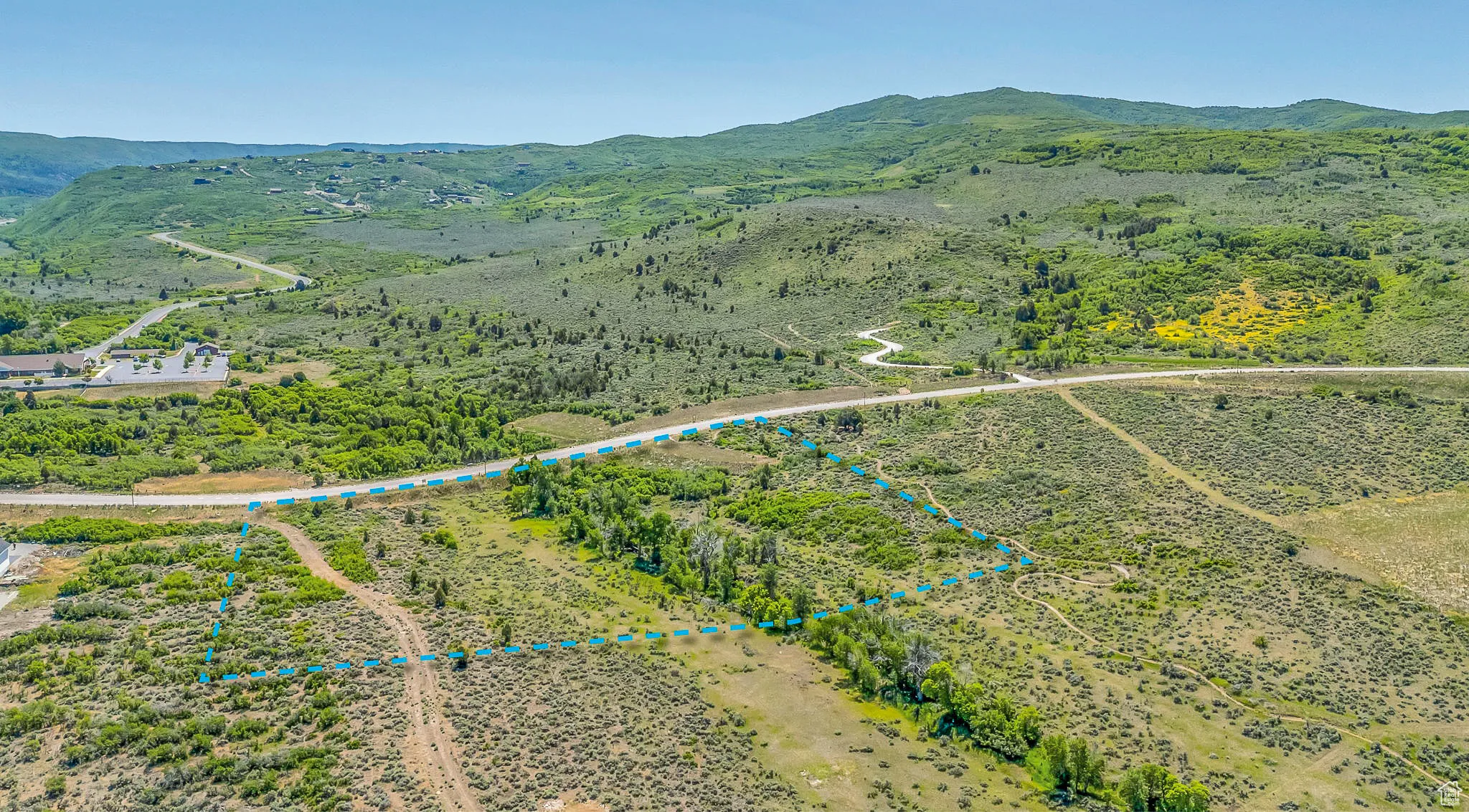 Aerial overview of property's location with a mountainous background and property parcel outlined