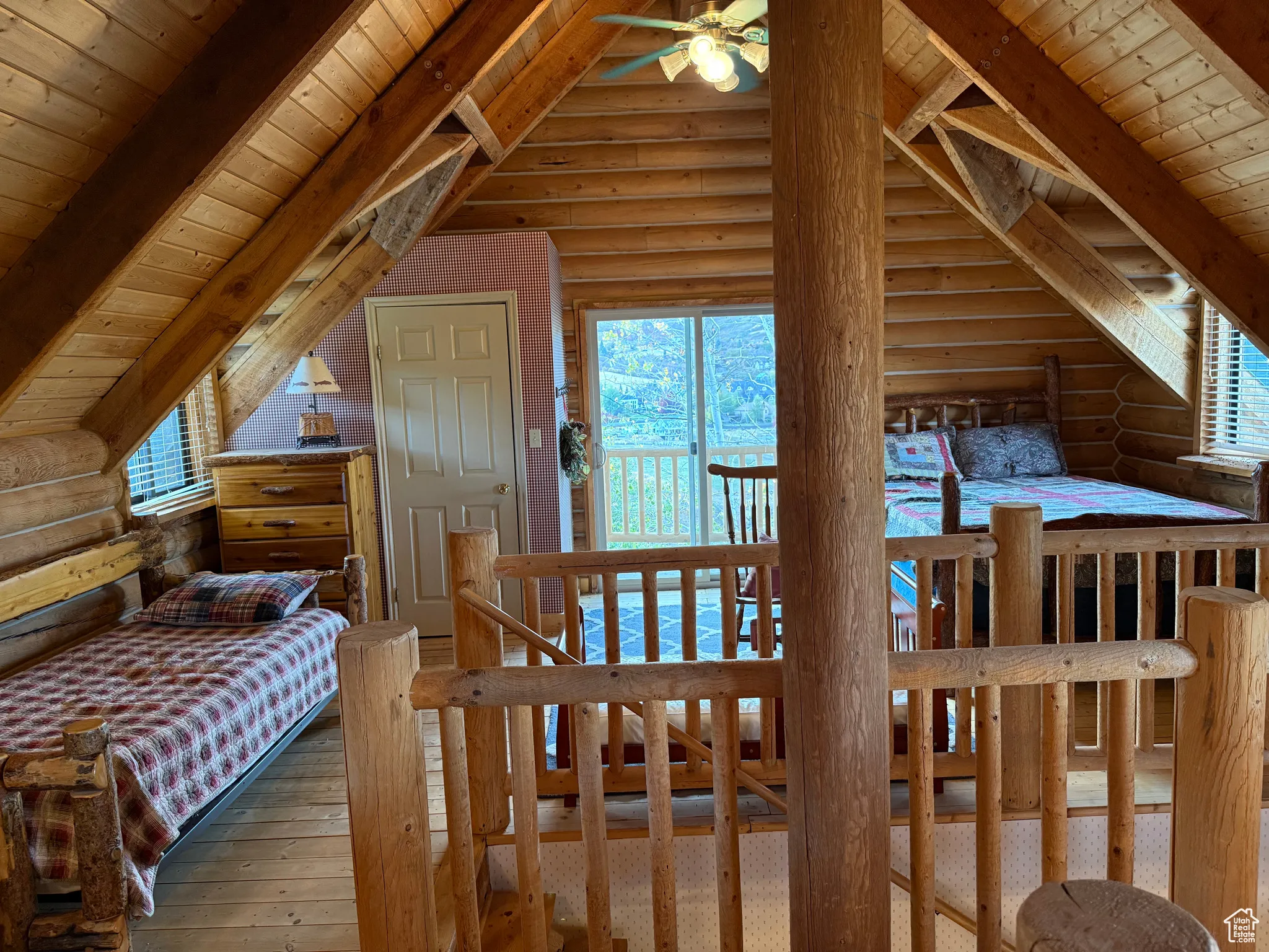 Bedroom featuring rustic walls, wood ceiling, wood-type flooring, and multiple windows