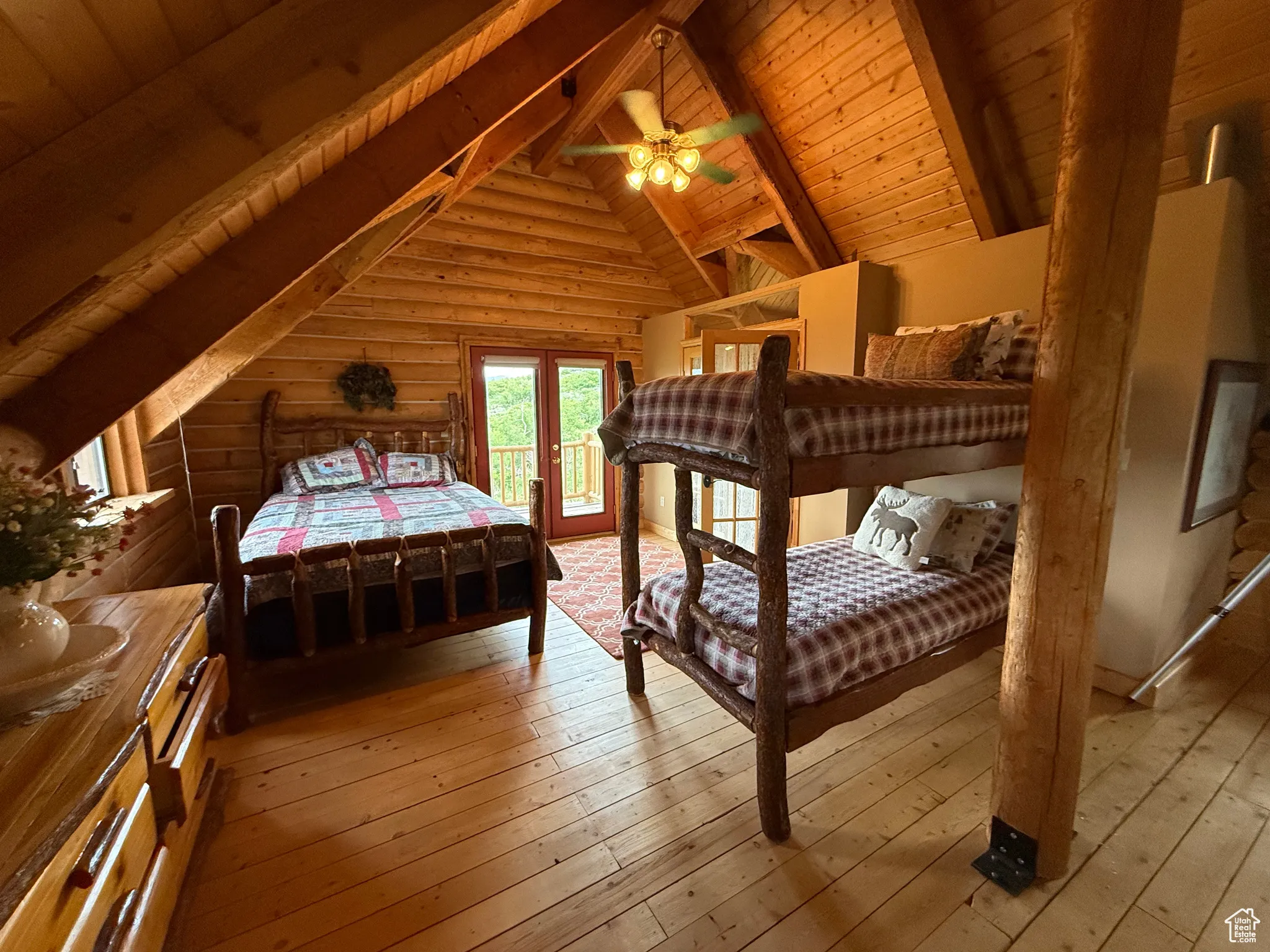 Bedroom featuring access to outside, hardwood / wood-style floors, wooden ceiling, and log walls