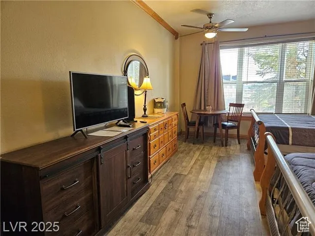 Bedroom with light wood-type flooring and crown molding