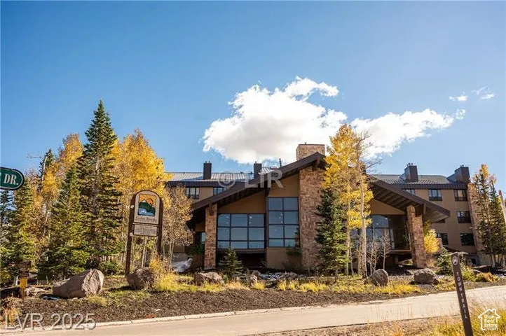 View of front facade with stucco siding and a chimney