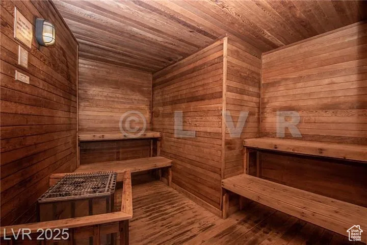 Relaxing sauna with wooden ceiling, wooden walls, and wood finished floors