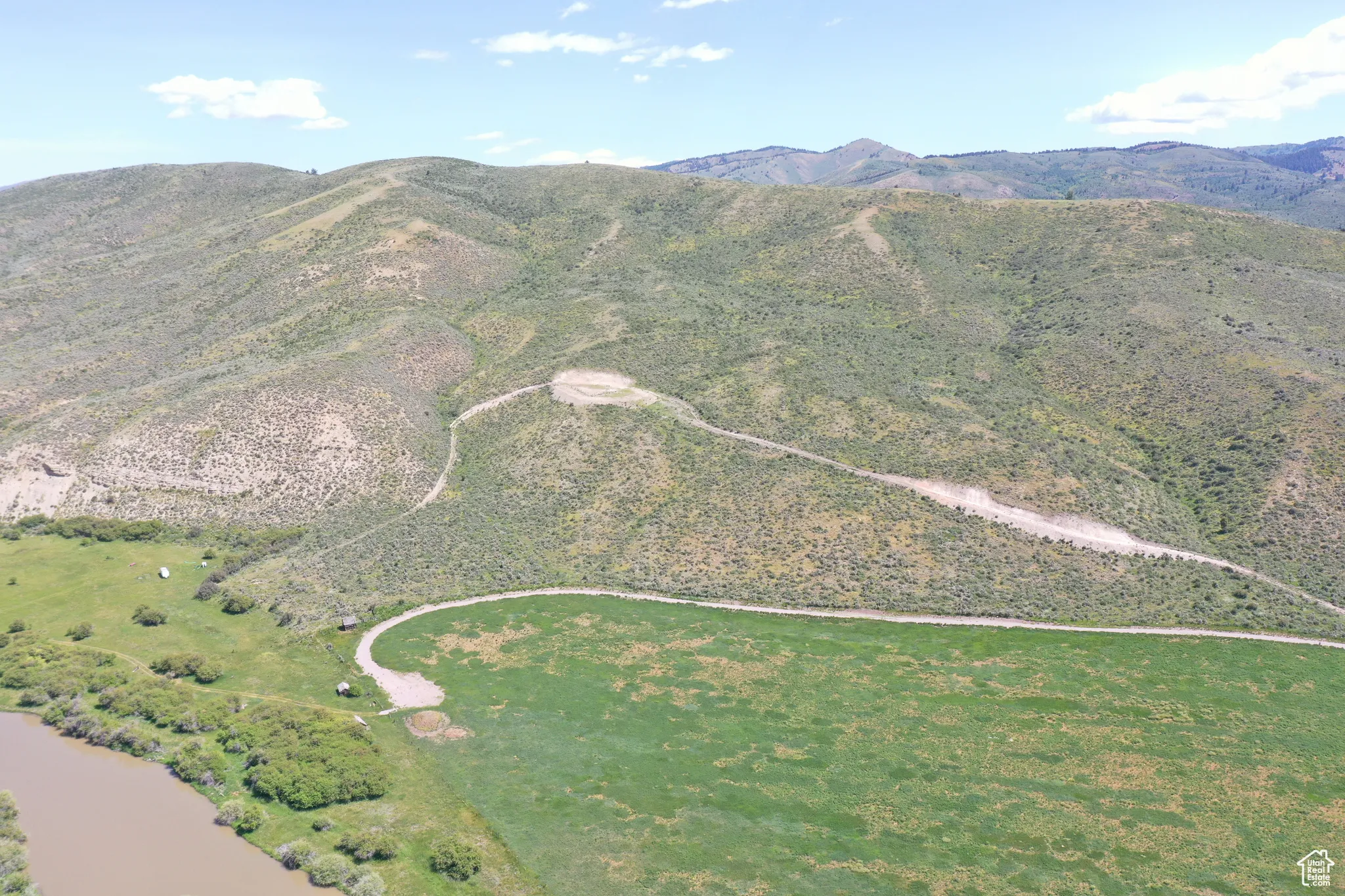 Aerial view of property and surrounding area with a mountain backdrop