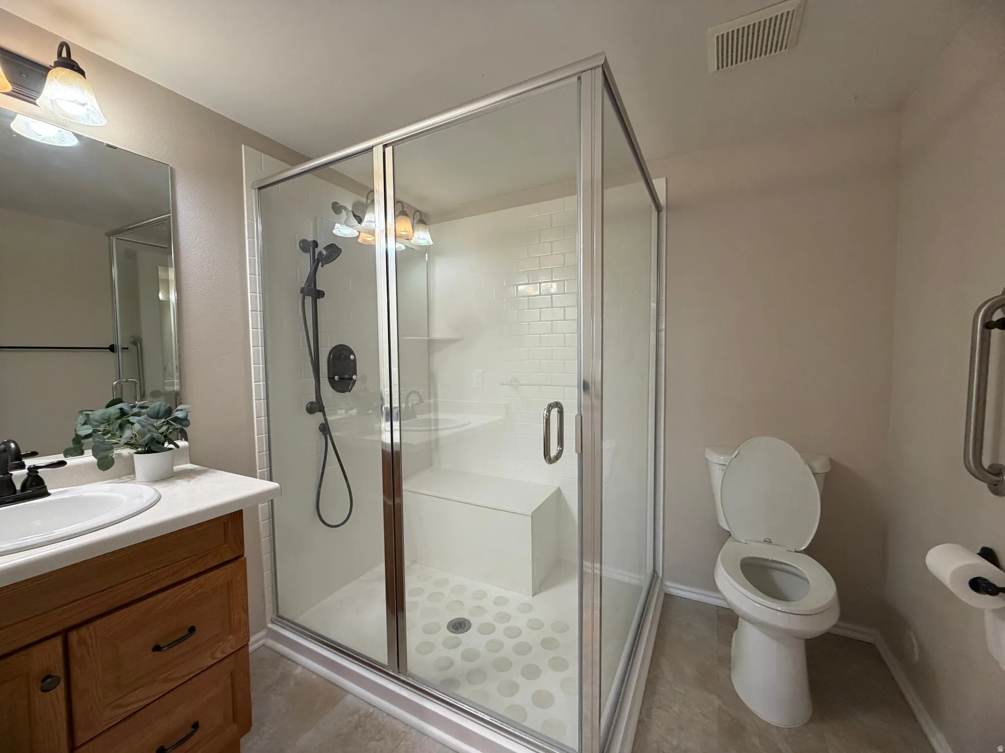 Full bath featuring vanity, a shower stall, and light tile patterned floors