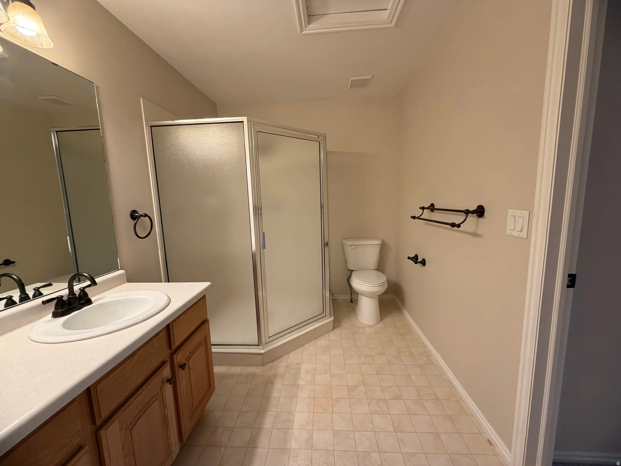Bathroom featuring vanity, a stall shower, and lofted ceiling