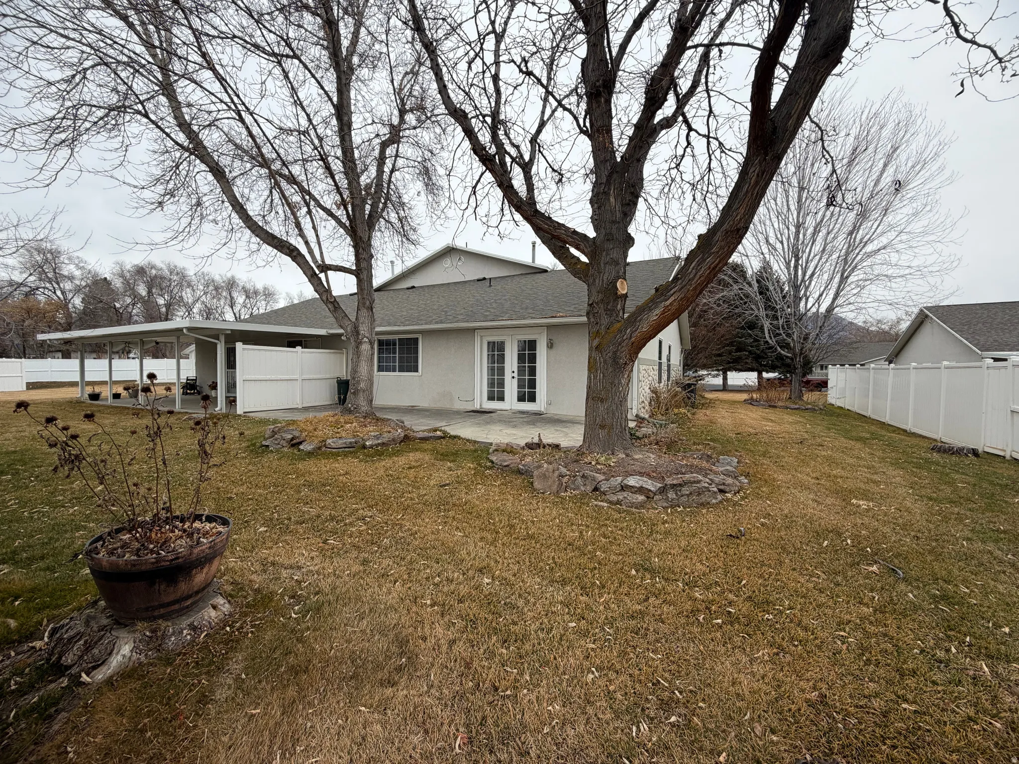 Back of house featuring french doors, a patio area, stucco siding, and a shingled roof
