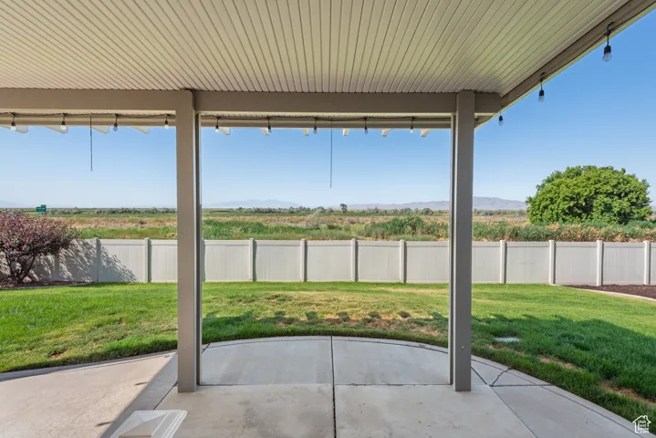 Fenced backyard featuring a patio area and a mountain view