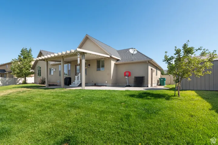 Rear view of house with a patio area and stucco siding