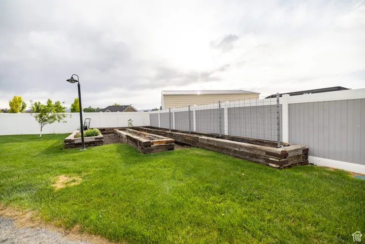Fenced backyard featuring a vegetable garden