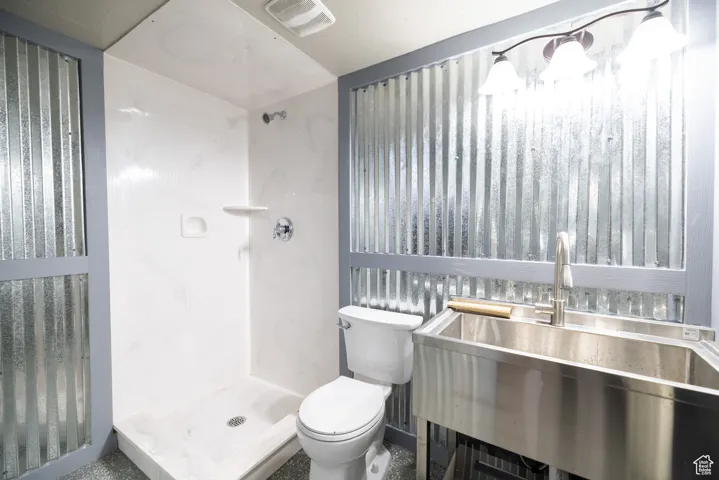 Full bathroom with toilet and a shower stall