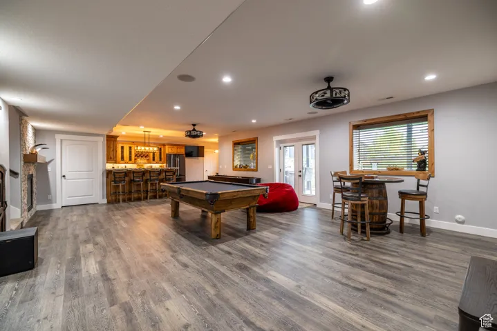 Game room featuring a bar, billiards table, dark wood-style flooring, recessed lighting, and french doors