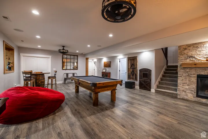 Recreation room with a fireplace, wood finished floors, recessed lighting, and billiards table