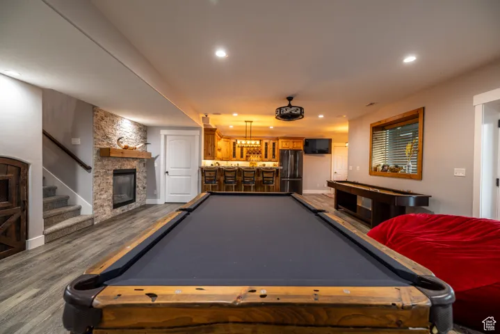 Game room with billiards, bar area, dark wood-style floors, recessed lighting, and a fireplace