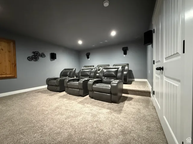 Carpeted home theater room featuring recessed lighting and baseboards