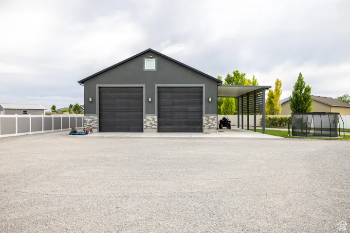 Garage featuring a trampoline and a detached garage