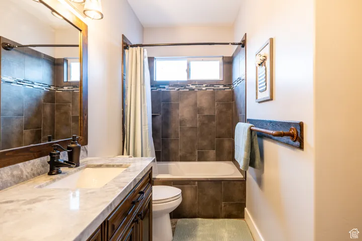 Full bath featuring vanity and shower / bath combination with curtain