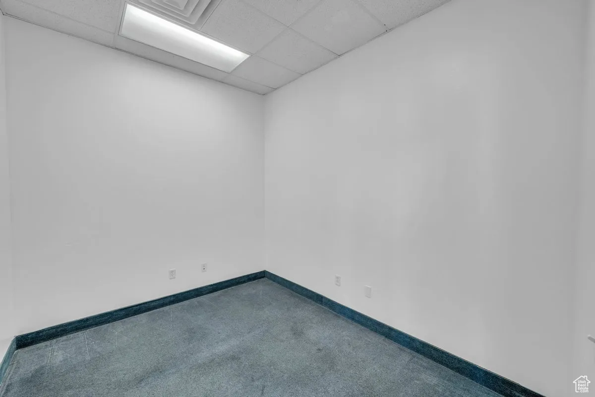 Unfurnished room with a paneled ceiling and carpet flooring