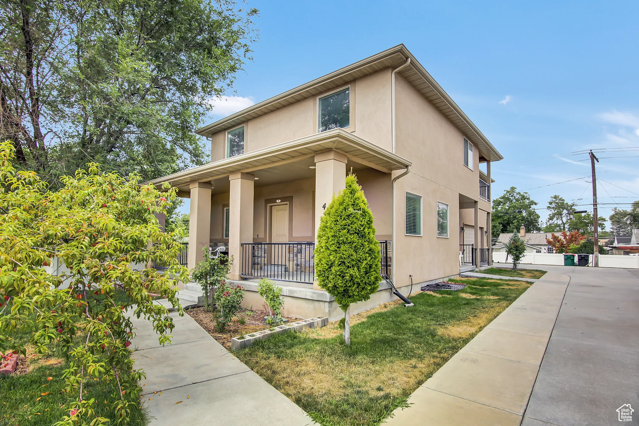 View of front of property with covered porch, stucco siding, and a front yard