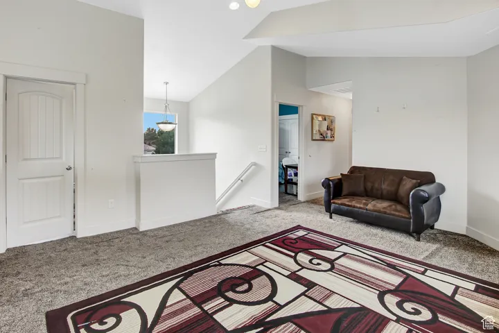 Living room with vaulted ceiling and carpet flooring
