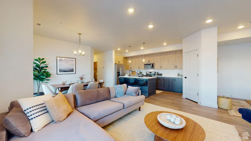 Living area featuring a chandelier, light wood-style flooring, and recessed lighting