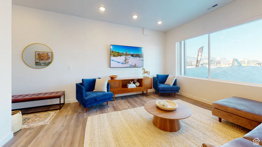 Living area with wood finished floors and recessed lighting